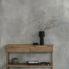 Tento odkládací stolek z masivního dubu kombinuje funkčnost s elegantním designem. Má dvě praktické zásuvky s charakteristickým drážkovaným čelem a minimalistickými úchyty, které dodávají moderní vzhled.