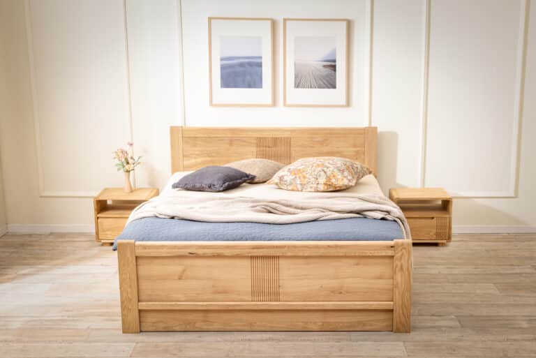 Dębowe łóżko Luise z litego drewna wnosi do sypialni ponadczasową elegancję i rzetelne rzemiosło. Subtelne frezowania, obłe krawędzie i naturalny rysunek dębu tworzą harmonijną całość, która ociepla wnętrze wizualnie i w dotyku. Praktyczny pojemnik pod podnoszonym stelażem w przedniej części łóżka oferuje sprytne rozwiązanie dla codziennego komfortu.